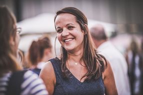 Eine Frau unterhält sich mit einer Freundin und lacht