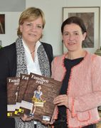 Zwei Damen halten das Familienzeit Magazin in den Händen und lachen in die Kamera.