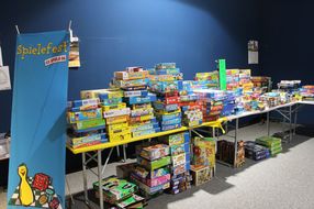 Unzählige Spiele sind beim NÖ Spielefest auf der Schallaburg auf einem Tisch aufgestapelt.