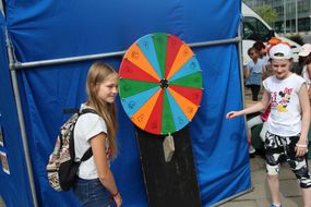 Zwei Mädchen stehen vor einem bunten Glücksrad beim Ferienauftaktfest 2017