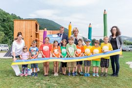 Kinder und Erwachsene lachen zusammen in die Kamera.