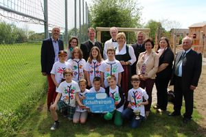 Landesrätin Schwarz lächelt zusammen mit Teilnehmerinnen und Teilnehmern der Eröffnung des Schulfreiraums in Maria Laach in die Kamera.