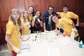 Sechs Kinder und ein Mann lachen bei der 3. Kinder Business Week in die Kamera