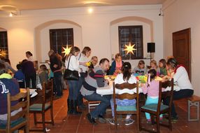 Spielende Personen sitzen beim NÖ Spielefest auf der Schallaburg zusammen an den Tischen.