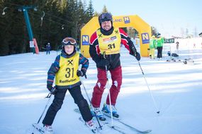 Mann und Bub posen mit Skiern für die Kamera