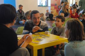 Mann erklärt Kindern Kartenspiel.