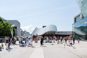 Viele Menschen stehen beim Straßenfest zum Weltspieltag vor dem Museum Niederösterreich