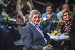 Mann lächelt beim Café Vierviertel in die Kamera