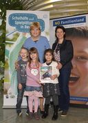 Drei Kinder und zwei Damen lachen in die Kamera.