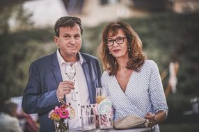 Ein Mann und eine Frau lächeln zufrieden in die Kamera