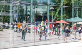 Kinder halten beim Straßenfest zum Weltspieltag gelbe und weiße Luftballons in der Hand