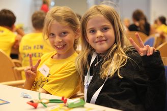 Zwei Mädchen lächeln auf der NÖ Kinder Business Week in die Kamera