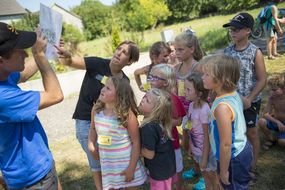 Kindern und Erwachsenen betrachten interessiert die Gestaltungsskizze des Spielplatzes