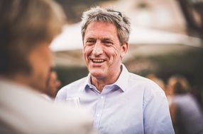 Mann unterhält sich mit jemandem und lacht 