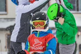 Bub mit Skihelm lächelt beim Familienskitag am 21. Jänner 2018 in die Kamera