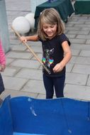 Ein Mädchen mit schwarzem Gewand hat Freude beim Spielen beim Ferienauftaktfest 2017