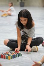 Ein Mädchen spielt bei der NÖ Kinder Business Week mit bunten Bausteinen