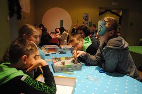 Kinder basteln eine Maske.