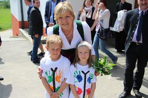 Landesrätin Schwarz lächelt in die Kamera mit zwei Kindern bei der Eröffnung des Schulfreiraums in Maria Laach