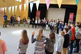 Mädchen und Buben der Spielforscher-Werkstatt in der Europa-Mittelschule Prinzersdorf stehen in einem Kreis und spielen ein Spiel.