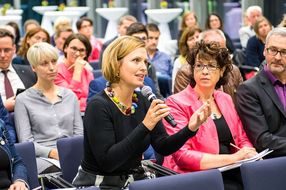 Frau aus dem Publikum spricht ins Mikrofon