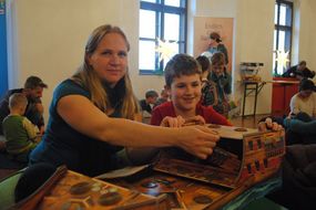 Frau und Bub beim Schiff zusammenbauen.