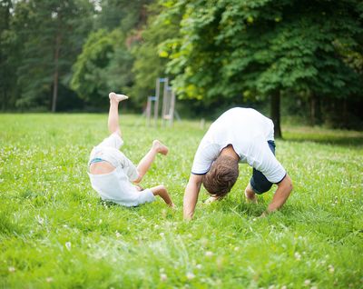 Zwei Buben machen im Garten einen Purzelbaum