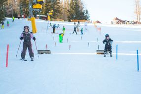 Kinder fahren bei den Familienskitagen 2017 die Skipiste hinunter