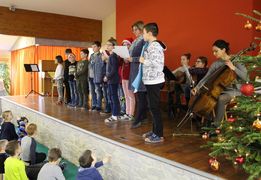 Kinder stehen auf der Bühne und tragen etwas vor.
