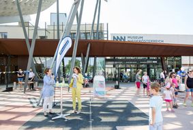 Zwei Damen sprechen beim Straßenfest zum Weltspieltag vor dem Museum Niederösterreich in das Mikrofon.