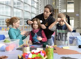 Kinder basteln zusammen mit einer Betreuerin