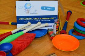 Wichtige bunte Utensilien für einen gelungenen Jonglierworkshop liegen am Boden