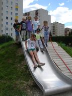 Kinder stellen sich für die silberne Rutsche an.