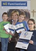 Landesrätin Schwarz lächelt mit drei Kindern in die Kamera.