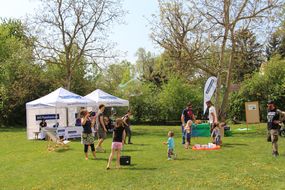 Kinder und Erwachsene spielen auf einer grünen Wiese beim Familienfest Donau-Auen