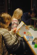 Eine Dame und ein Kind spielen zusammen beim 13. NÖ Spielefest auf der Schallaburg