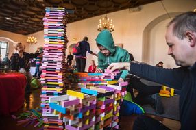 Bub und Mann bauen beim 15. NÖ Spielefest auf der Schallaburg mit bunten Bausteinen einen Turm
