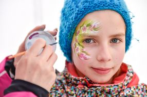 Mädchen wird bei den Familienskitagen 2017 mit Blumen geschminkt