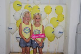 Zwei Schwestern lachen bei den NÖ KinderSommerSpielen 2016 in die Kamera.