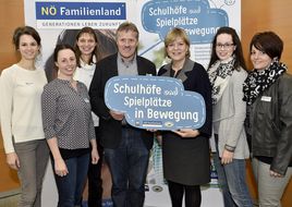 Landesrätin Schwarz hält mit einem Mann beim Seminar "Schul(t)räume" ein Schild in die Kamera.