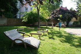 Hölzerne Sonnenstühle bei einem Spielplatz.