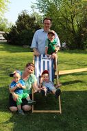 Bub liegt beim Familienfest Donau-Auen in blau-weißem Liegestuhl und hat ein Eis in der Hand