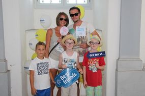 Eine Dame, ein Mann und drei Buben halten bei den NÖ KinderSommerSpielen 2016 lustige Schilder in die Kamera.