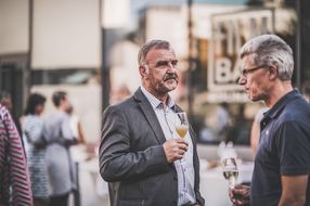 Zwei Männer mit einem Glas in den Händen