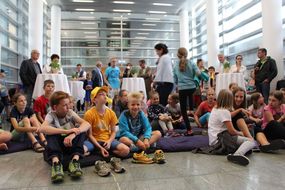 Kinder sitzen beim Ferienauftaktfest 2016 zusammen am Boden.