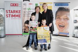 Landesrätin Schwarz lacht mit einer Dame und zwei Buben bei der 4. NÖ Kinder Business Week in die Kamera.