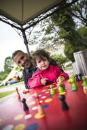 Mann und Kind spielen Mensch ärgere dich nicht beim NÖ Familienfest auf der Schallaburg