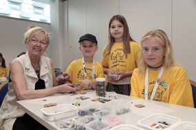 Drei Kinder und eine Frau basteln bei der 3. Kinder Business Week gemeinsam