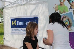 Mädchen wird beim Familienfest Donau-Auen kreativ geschminkt