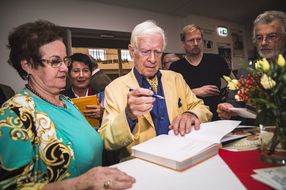 Eine Dame lässt sich ein Autogramm geben.